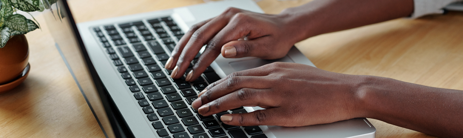 Main d'une femme qui travaille sur son ordinateur portable dans le cadre de la déclaration DADS-U et la DSN en 2019