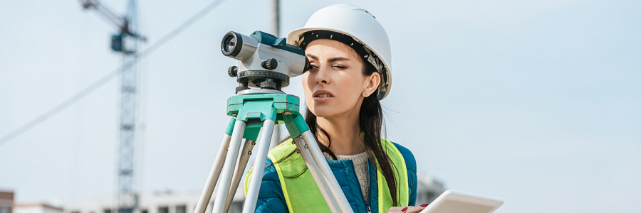 Une femme dans le BTP qui utilise un niveau de chantier pour évoquer le recrutement dans le BTP