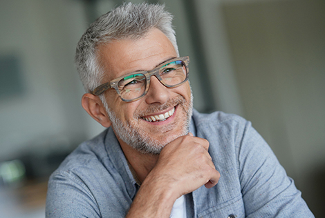 2 Photographie d'un homme aux cheveux gris avec des lunettes souriant pour évoquer la protection des yeux et de la vue au quotidien selon la MBTP