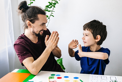 2 Un homme et un enfant autiste font une activité créative et cognitive dans le cadre de la journée mondiale de l'autisme