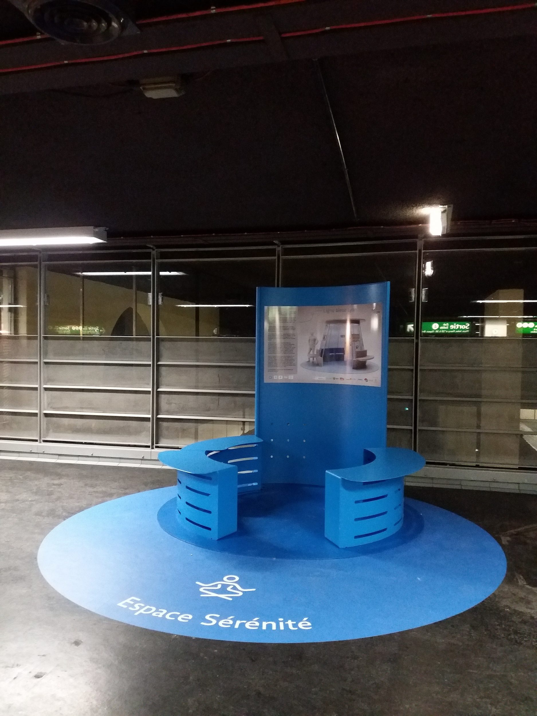 Un banc en cercle avec une signalétique pour indiquer qu'il s'agit d'un espace de sérénité dans dédié au dispositif de la ligne bleue pour aider les personnes atteintes d'autisme