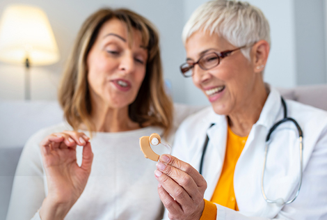 2 Deux femmes, une patiente et une médecin, discutent autour d'un appareil auditif dans le cadre du 100% santé audition