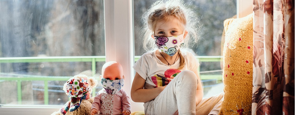 Photographie d'une petite fille masquée avec ses poupées aussi masquées pour évoquer les troubles psychologiques des enfants durant la crise sanitaire du covid19 et des séances de psychologue prévus par l'Assurance Maladie